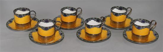 A set of six Royal Worcester silver-mounted coffee cans and saucers, with six enamelled silver-gilt coffee spoons